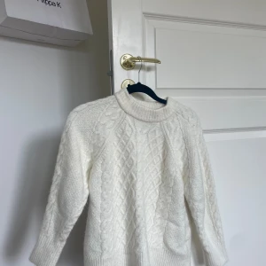 Vit stickad tröja - Säljer en superfin vit stickad tröja från Lager 157. Den har ett snyggt mönster och är perfekt för kyliga dagar. Tröjan har trekvartsärm och en bekväm passform. Perfekt för både vardag och fest! 🤍Storlek S men passar XS.