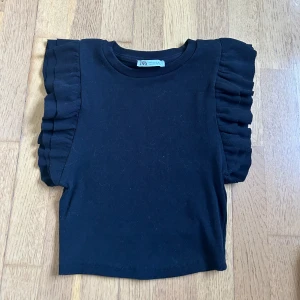 Topp m. volanger - Snygg topp med volanger från Zara som inte kommit till användning!