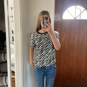 Zebramönstrad T-shirt  - En jättesnygg zebramönstrad T-shirt i svart vit använd en gång. Jättesnygg till ett par blå jeans  