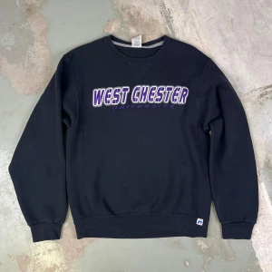 Russell Athletic - College Sweatshirt - Cool svart college sweatshirt med brodering "West Chester Unicersity" fram  och tryck "WCU" baktill.  Material 50% Bomull 50% Polyester  