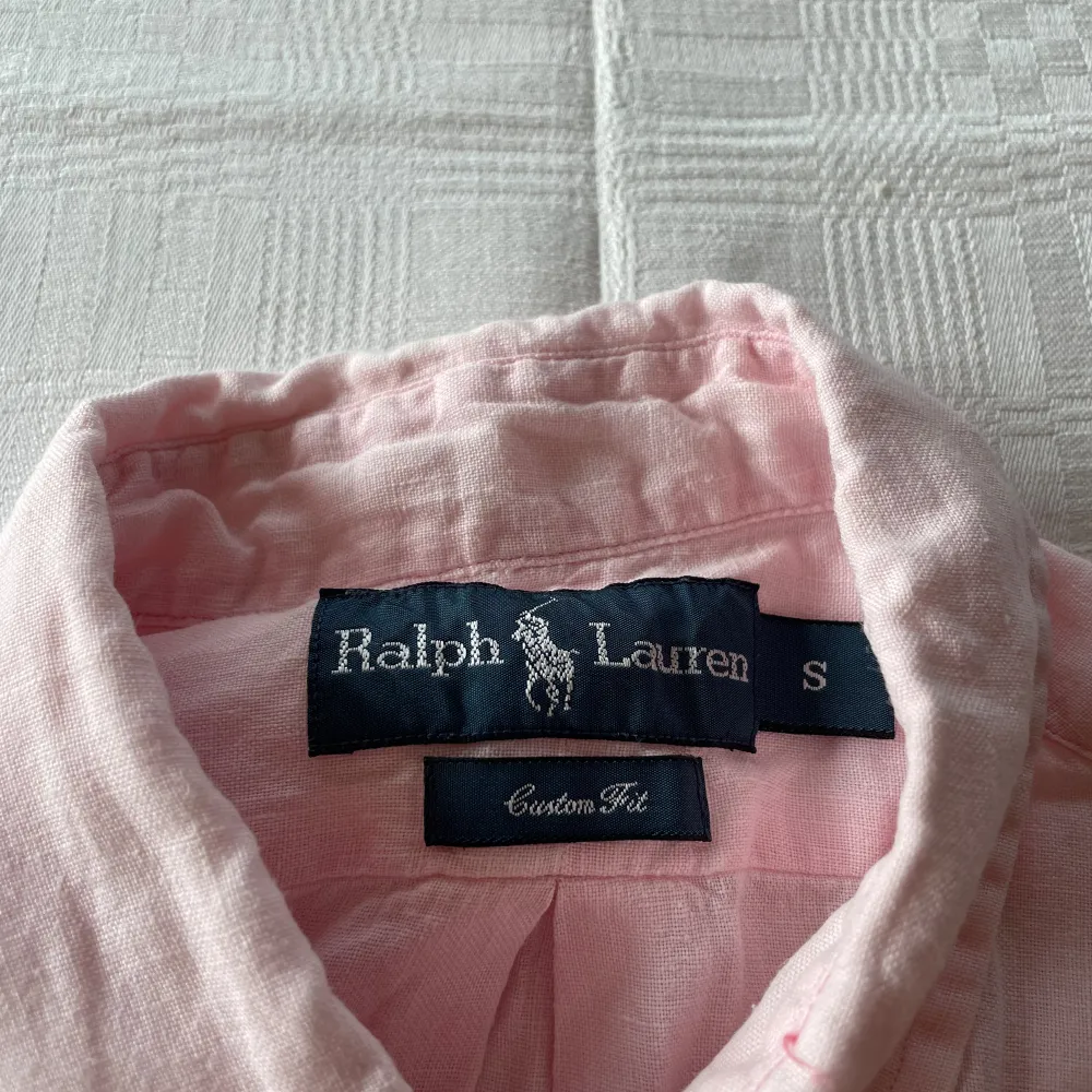 Säljer en snygg rosa skjorta från Ralph Lauren i storlek S. Skjortan är långärmad och har en klassisk krage med knappar. Den är tillverkad i ett mjukt bomullsmaterial och har en broderad logga. Skriv vid minsta lilla funderingar . Skjortor.