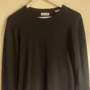 Tröja från Jack & Jones  - Säljer en stilren svart crew neck tröja perfekt för en enkel och klassisk look. Tröjan har en rund halsringning och är gjord i ett mjukt material. Använd typ 1-2 gånger och helt nytt skick. Skriv för fler frågor eller bilder🙌