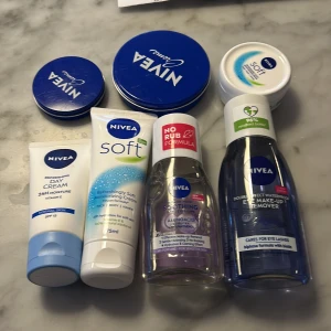 Hudvårdsprodukter från Nivea - Samling av Nivea-produkter inklusive Soft Moisturizing Cream och Refreshing Day Cream. Perfekt för daglig återfuktning och vård av ansikte, kropp och händer. Innehåller vitamin E och erbjuder 24 timmars fukt. Kommer i praktiska tuber och burkar.