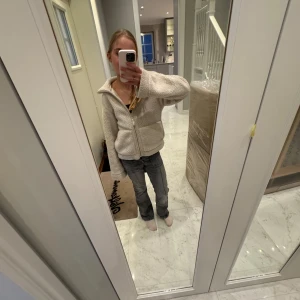 Grå jeans med bootcut i storlek 152 - Snygga grå jeans med bootcut-stil och låg midja. De har framfickor och en knappdetalj i midjan. Perfekta för en avslappnad look. Storlek 152