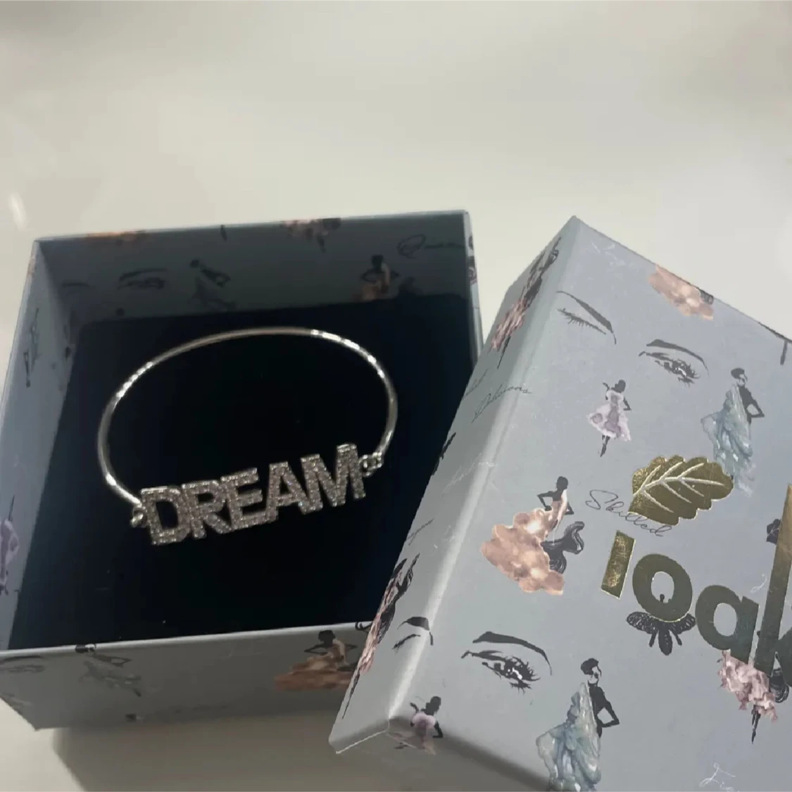 Silverfärgat armband med texten DREAM från Ioaku - 1