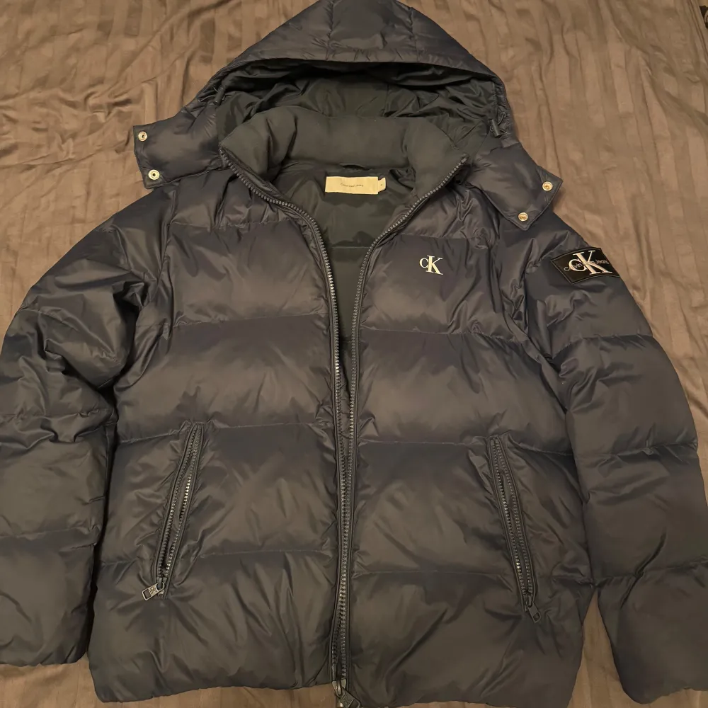 Tja, säljer min CK jacka då jag köpt en ny jacka o denna inte används. Köpte den för 2 700 kr och har knappt använt den i 2 månader. Skicket skulle jag säga är 10/10 då det inte finns något slitage alls på jackan! Bara att höra av dig om intresserad!😉. Takit.