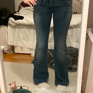Blå diesel bootcut jeans - Snygga blå bootcut jeans med en klassisk femficksdesign. De har en lågmidjad passform och är perfekta för en avslappnad stil. Jeansen har en lätt tvättad look som ger dem en trendig touch. Skit snygga men säljer då jag inte använder de tillräckligt☺️ Aka mäta ikväll eller imorgon sen skriver jag måtten här ☺️