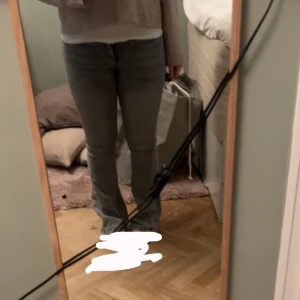 Grå jeansbyxor - Snygga grå jeansbyxor med en tight passform. Perfekta för en stilren look. De har en klassisk design med en rak siluett och är ett mångsidigt tillskott till garderoben. Lite slitna längst ner men absolut inget man tänker på