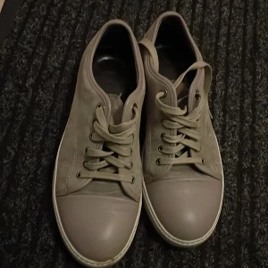 Beige sneakers från Lanvin - Snygga beige sneakers från Lanvin med snörning och rund tå. Skorna har en stilren design med en ljus sula som ger en modern touch. Perfekta för en avslappnad stil. Det är lite smuts där fram men tar bort de innan jag skickar dom! Priset kan diskuteras vid snabb affär!