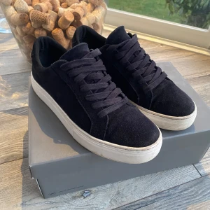 Mocka skor från Vagabond - Marinblå sneakers i mocka med vit sula, från Vagabond i modell Paul 2.0 i storlek 41. Skick 8/10 varsamt använda. Priset är ej hugget i sten, tveka inte att höra av dig vid frågor, funderingar eller om du vill ha fler bilder🙌