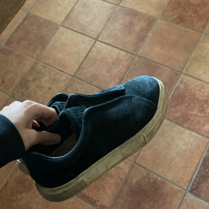 Svarta sneakers från Eytys - Snygga svarta sneakers från Eytys i mocka med en stilren design. Skorna har en robust sula och är perfekta för en casual look. De är i storlek herr 41 och har en bekväm passform.