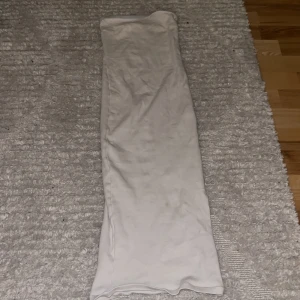 Vit ribbad klänning från Gina Tricot - Säljer en stilren vit ribbad klänning från Gina Tricot i storlek XS. Klänningen är axelbandslös och har en tight passform som framhäver figuren. Perfekt för sommarens alla fester eller en dag på stan. Materialet är mjukt och stretchigt för extra komfort. Hör av dig vid intresse! 🤍