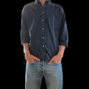 Mörkblå skjorta från Ralph Lauren - Säljer en snygg mörkblå skjorta från Polo Ralph Lauren i storlek M. Jag köpte den här på Plick med den passar tyvärr inte mig och säljer därför vidare den, skriv för fler bilder.