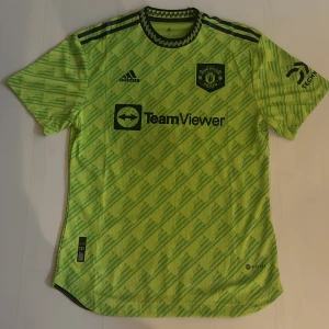 Fotbollströja  - Jag säljer Manchester United tredjeställ player version säsongen 22/23  Använd en gång och tvättad en gång. Väldigt bra skick. 