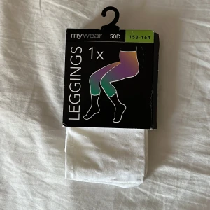 Vita leggings från MyWear - Säljer ett par vita leggings från MyWear i storlek 158-164. De är gjorda av en mjuk och stretchig polyesterblandning, perfekt för vardagsbruk eller som ett extra lager under klänningar och kjolar. De är helt nya och oanvända, fortfarande i förpackning. Perfekta för både vår och sommar! Oöppnade. Djur och rökfritt hem.