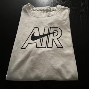 Vit tröja från Nike - Säljer en snygg vit tröja från Nike med det klassiska 'AIR' trycket på framsidan. Perfekt för en avslappnad stil eller träning. Tröjan är i bra skick och passar till det mesta. Skicka ett meddelande vid intresse!