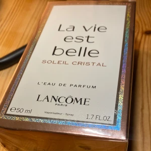 La Vie Est Belle Soleil Cristal Eau de Parfum - Säljer en elegant och lyxig parfym från Lancôme, La Vie Est Belle Soleil Cristal. Flaskan innehåller 50 ml av denna underbara doft. Förpackningen har en skimrande och glittrande design som verkligen fångar ögat. Perfekt för den som vill känna sig extra speciell varje dag!