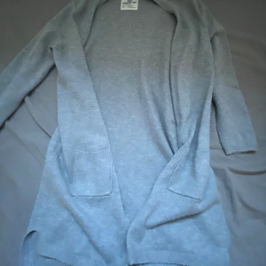 Lång kofta - Lång stickad grå kofta med två fickor för barn runt 10års åldern  