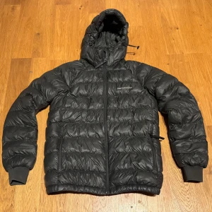 Peak performance jacka - Peak Performance jacka puffer Storlek 170 cl Fint skick. Använd av ett barn en säsong. Inga fläckar. En liten lagning på ena ärmen, se bild. Syns knappt och inget som stör.  Avtagbar luva med snygg Peak-logga  Kontakta vid frågor