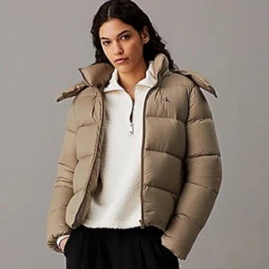 Beige pufferjacka från Calvin Klein - Säljer en snygg beige pufferjacka från Calvin Klein. Jackan har en dragkedja framtill och är perfekt för kyliga dagar. Den är i mycket bra skick och passar perfekt för höst och vinter. Jackan har långa ärmar och en stilren design som funkar till det mesta. Perfekt för dig som vill hålla stilen i kylan! Köpt för 2500kr