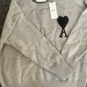 Ami pari - En fin grå tröja trån Ami paris. Tröjan är helt ny och oanvänd. Tröjan har storleken S.