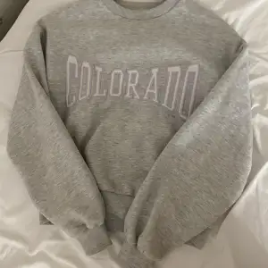 Grå sweatshirt från gina tricot med ”Colorado” text på framsidan i vitt. Skönt material och insida. Säljer pga att den inte är min stil längre. Köpte för 300kr men är lite använd. 💗