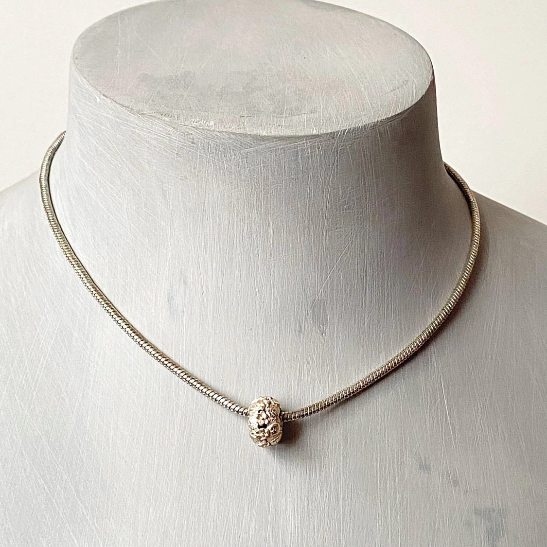 Elegant silverfärgat halsband med dekorativ pärla