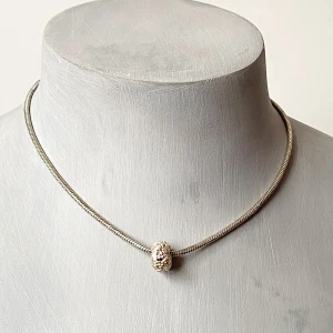 Elegant silverfärgat halsband med dekorativ pärla - Säljer ett stilrent halsband i silverfärg med en unik, dekorativ pärla i mitten. Halsbandet har en smidig kedja och justerbar längd för perfekt passform. Perfekt för både vardag och festliga tillfällen. Ett måste för den som älskar minimalistisk design!