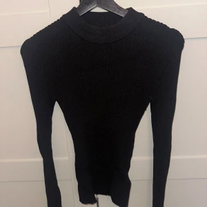 Glittrig topp - Svart stickad glittrig tröja. Perfekt till vardags då den är ganska diskret men också perfekt till fest då den glittrar lite. Den är i M men passar mellan S-M skulle jag säga då den är stretchig🖤🥰 Använd typ 1 gång!