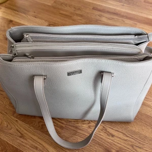 handväska - perfekt till skolan, rymlig med flera fack inkl datorfack. axelbandet kan knäppas av. bredd: 40cm, höjd: 26cm, djup: 15 cm. nästintill oanvänd med finns några fläckar i botten (bild 5)