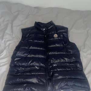 Moncler väst - Väst i väldigt bra skick, dragkedjan fungerar dock ej, passar allt mellan S-XL då man inte behöver knäppa, då den inte är hel så kan pris självklart diskuteras