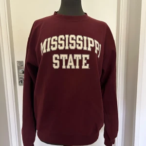 Vinröd Mississippi State sweatshirt - Säljer en vinröd sweatshirt från champion. Tröjan är i väldigt bra skick