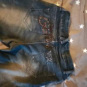 Straight Ed Hardy Jeans. Köpta på vinted. Tredje bilden e förra ägarens bild. Helt ok skick,midjan är sydd till 37/38cm rakt över av förra ägaren. syns dock inte att den är sydd när man har dem på sig! Många diamanter har lossnat. Innerbenslängd 77cm