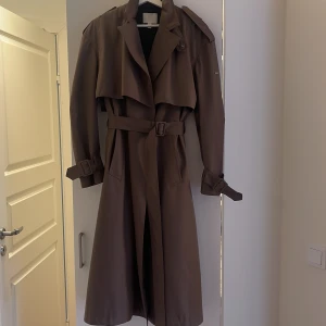 Trenchcoat aimn M - Jättefin jacka i kanonbra skick. Hög kvalitet och väldigt lite använd. Vind och vattentålig i strl M