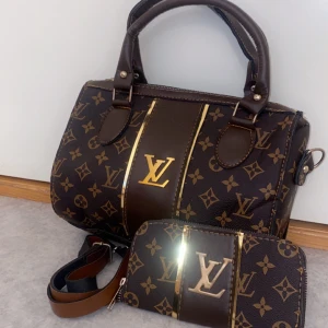 Handväska  - Väskan är knappt använd och är i mycket bra skick. Med väskan ingår det plånboken. PRIS KAN DISKUTERAS! 