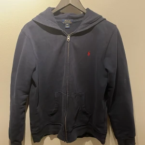 Ralph lauren zip hoodie - Denna zip hoodien är använda fler tals gånger. Hål i en av arm muddarna och är även ut stretchad men annars är den bra