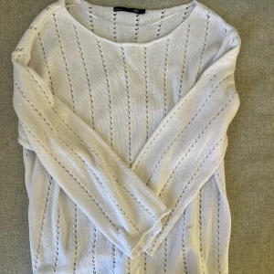 Långärmad tröja  - Långärmad stickad tröja med ”hål”. Den är lite lätt genomskinlig och med båt u-ringad hals. Helt oanvänd.