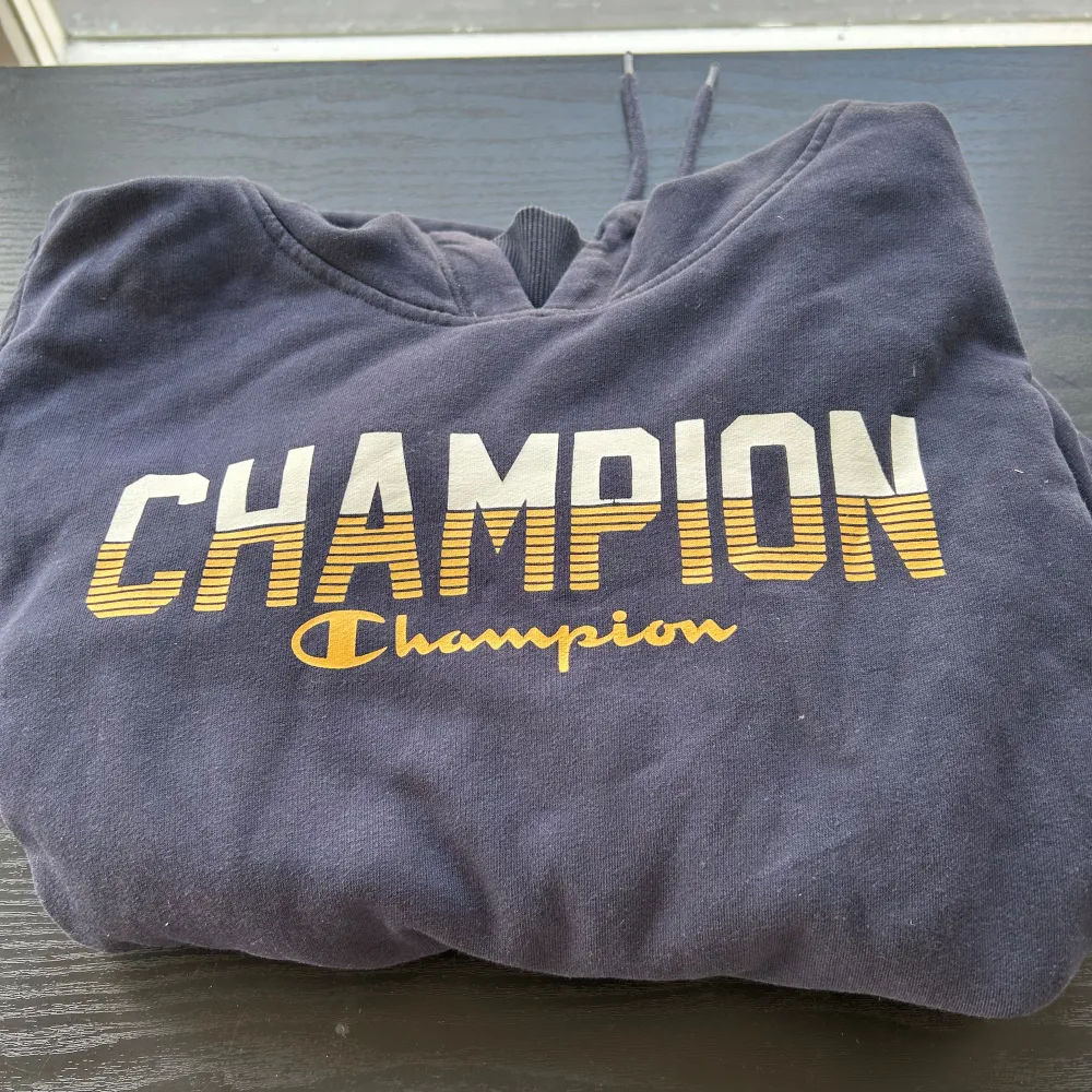 Marinblå Champion hoodie. Använd några gånger men har inga fläckar, hål, skador eller andra defekter. Är i storlek M men skulle säga att den är lite mer ”slimad” i modellen, sitter mer som en S.. Hoodies.