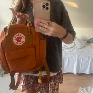 Orange ryggsäck från Fjällräven - Säljer en supersöt orange/brun kånken ryggsäck från Fjällräven. Den är perfekt skick då den knappt är använd! 