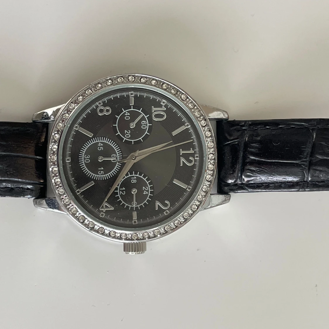 Svart klocka med silverdetaljer - 90