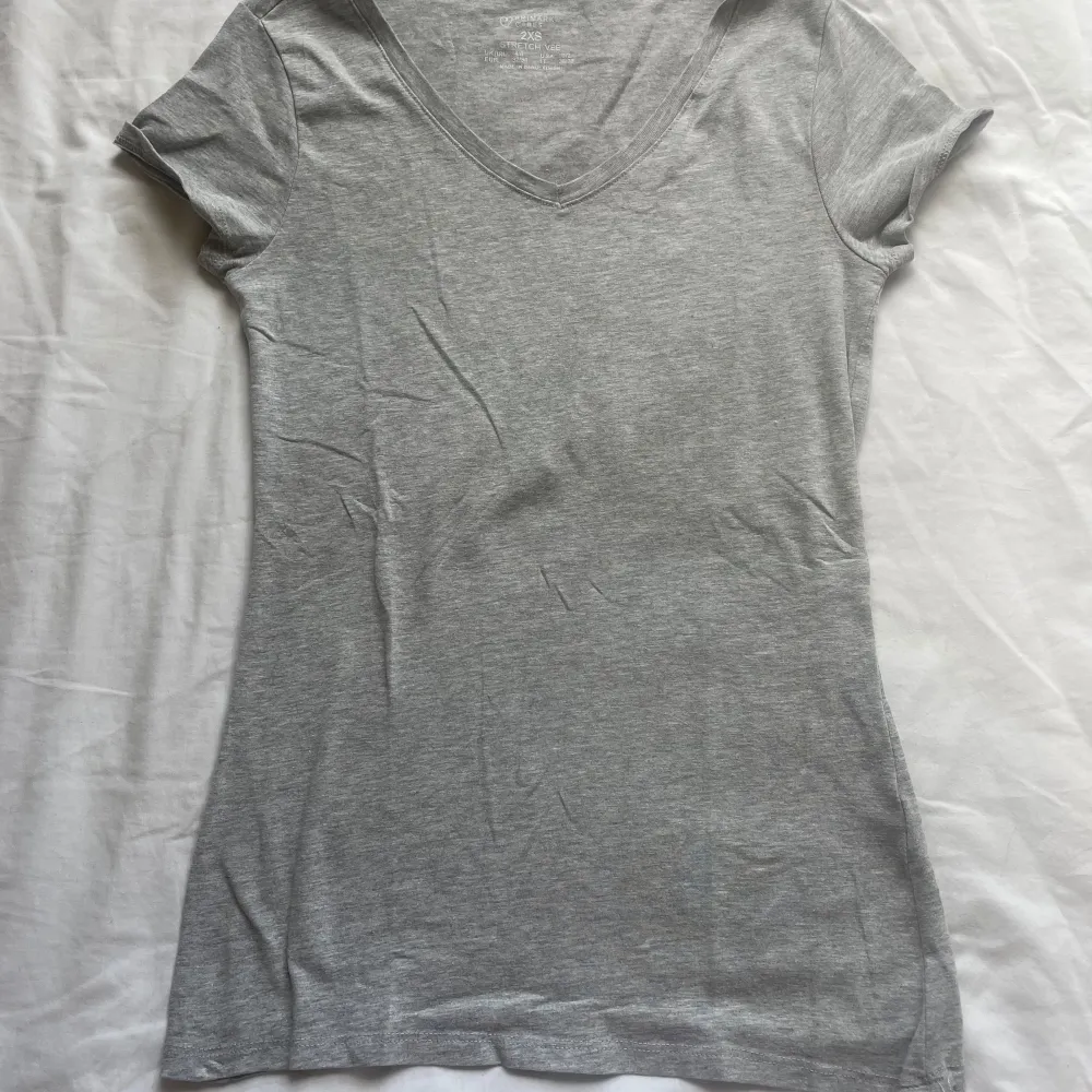 Säljer en grå t-shirt från Primark i storlek XXS. Den är gjord av bomull och har en v-ringad hals. Perfekt för vardagsbruk och kan matchas med nästan vad som helst. T-shirten är i bra skick och väldigt bekväm att ha på sig.. T-paidat.