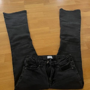Svarta jeans från Grunt - Säljer ett par svarta jeans från märket Grunt. De är i bra skick och har en klassisk femficksdesign med dragkedja och knapp framtill. Jeansen har en utsvängd passform och är tillverkade i ett bekvämt denim-material. 