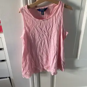 Säljer en söt rosa ärmlös topp från Polo Ralph Lauren. Den är i storlek L (12-14) och har fina spetsdetaljer längst ner. Perfekt för sommaren!💖 priset kan diskuteras 💕