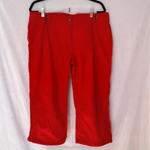 Röda Piratbyxor från North Bend - Säljer ett par snygga röda piratbyxor från North Bend i storlek 44. Byxorna har en normal passform. De har en dragkedja och knapp framtill samt praktiska fickor. Perfekta för en färgglad och bekväm stil!