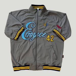 Enyce jersey - Jersey från Enyce med dragkedja framtill och broderad text i ljusblått och gult! Bra skick, förutom en maska som gått upp (bild 4). Strl står ej men skulle säga herr L 😁