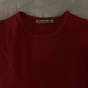 Röd t-shirt från Acne Studios - Snygg röd t-shirt från Acne Studios i en klassisk design. Använd men bra skick! Pris kan disskuteras!