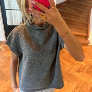 Grå kortärmad tröja - Säljer en stilren grå tröja med korta ärmar. Perfekt för en avslappnad look, och den är superbekväm. Passar bra till både jeans och kjol. Perfekt för vår och sommar!