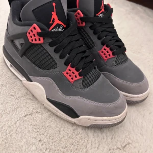 Nike Air Jordans 4 infrared - Säljer ett par grymma Nike Air Jordans i grått med röda detaljer (infrared). Perfekta för både vardag och för en kollektion! De är i bra skick med lite slitage på sulan. Skick 8/10