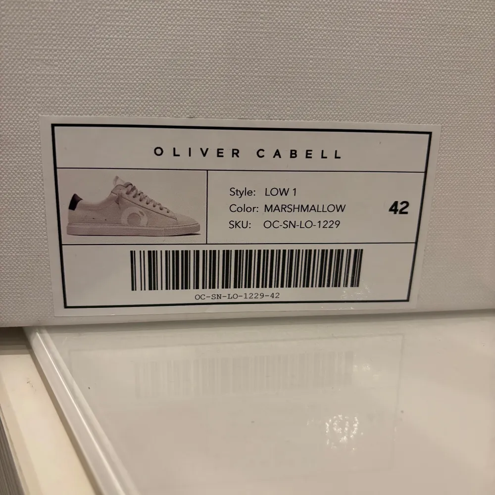 Säljer ett par snygga beige sneakers från Oliver Cabell i modellen Low 1. De har en stilren design med snörning och en diskret logga på sidan. Färgen är 'Marshmallow' och de är i bra skick. Perfekta för både vardag och fest!. Skor.