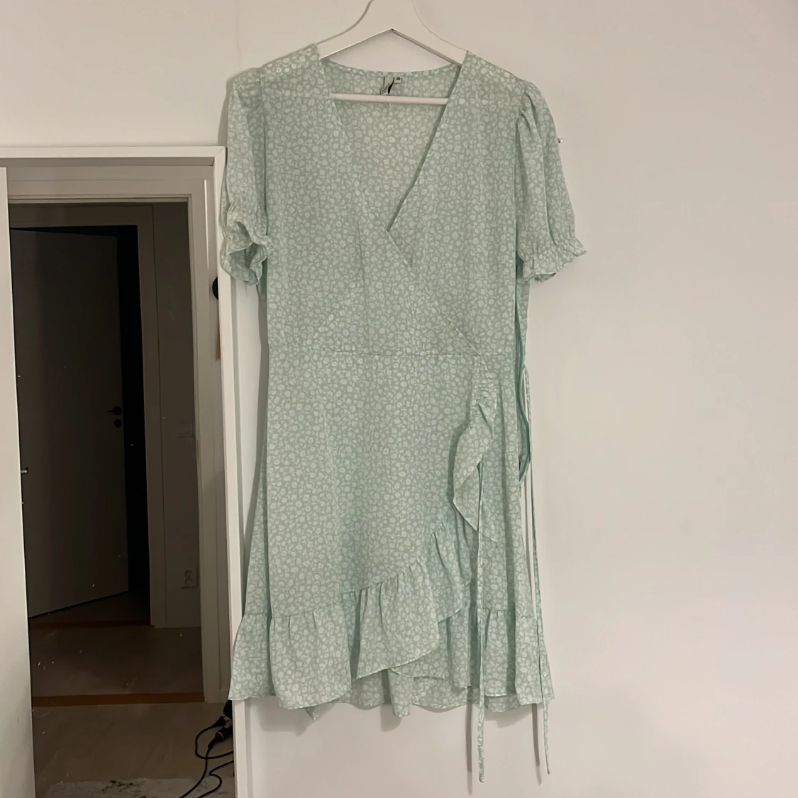 Ljusgrön blommig omlottklänning